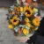 Композиция в сумке "Тональность" из подсолнухов, калл, ягод вибирнума, лимонных роз, скиммии и орхидеи в Долгопрудном